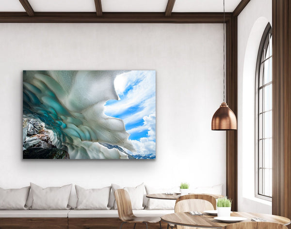 An ice cave photography canvas by Shel Neufeld hangs in a living room. It is a large piece for the feature wall. 