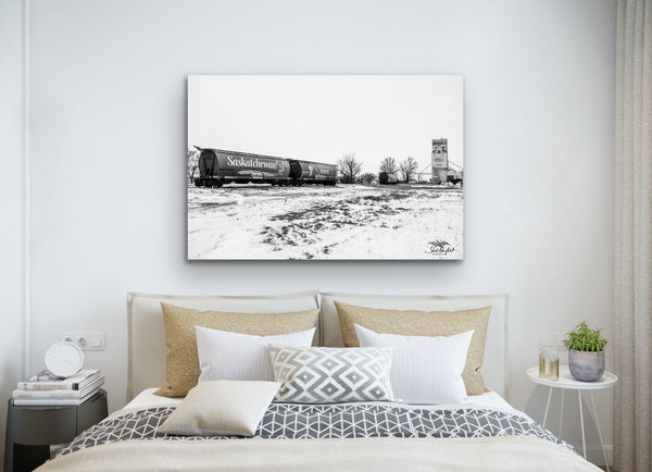 Black and white Saskatchewan Train photography canvas hangs in a bedroom over the bed. Artwork by Shel Neufeld, Canadian landscape photographer. 