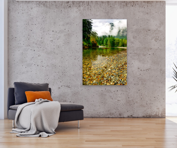 Gold Creek at Golden Ears Provincial Park in BC is captured by Shel Neufeld. A beautiful pebble beach with clear water , green trees, mountains and clouds hanging low. This photograph is available to purchase as a print in a variety of sizes. 