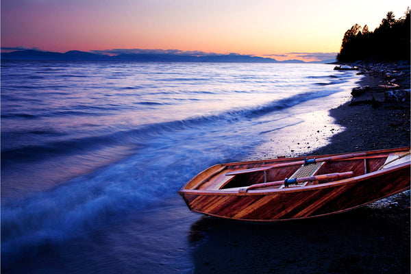 Wooden boat on beach with sunset - orange, blue and pink sky - Nautical photography by Shel Neufeld, Canadian nature Photographer
