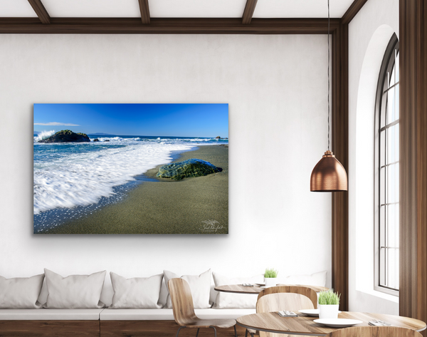 Beach landscape New Wya Point with Wave Splash Canvas print hangs on a wall in a living room scene. Artwork by Shel Neufeld. 