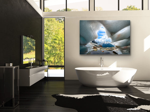 Ice cave mountain landscape photography canvas hangs in a bathroom above a large soaker tub. Artwork by Shel Neufeld, Canadian landscape and nature photographer. 