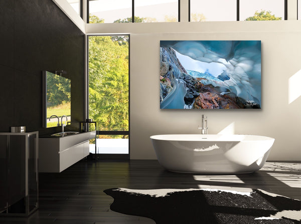 Mountain Ice Cave photography canvas hangs above a large soaker bathtub in a bathroom. Artwork by Shel Neufeld. 