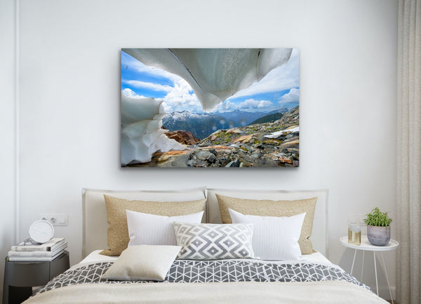 Blue and white ice cave photography canvas hangs on the wall above a bed. Photography by Shel Neufeld.