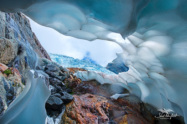 Blue and white ice cave on rugged mountain top by Shel Neufeld from Roberts Creek, BC, Canada.