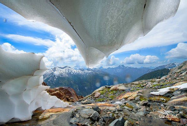 A snow cave is in the mountains of BC. The cave's ice starts to melt with water streams in the picture. Photograph captured by Shel Neufeld, Canadian nature and landscape photographer. 
