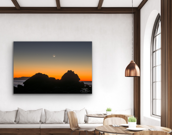 Sombrio Beach orange sunset with moon photography canvas hangs in a living room. Photography by Shel Neufeld from Roberts Creek, BC, Canada.