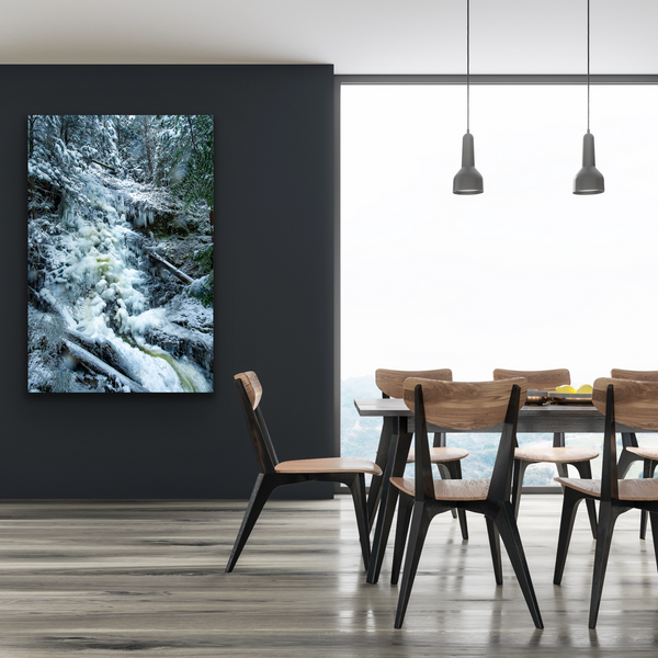 An icy waterfall is captured by Shel Neufeld. The photograph is made into a large canvas and hangs in a dining room. 