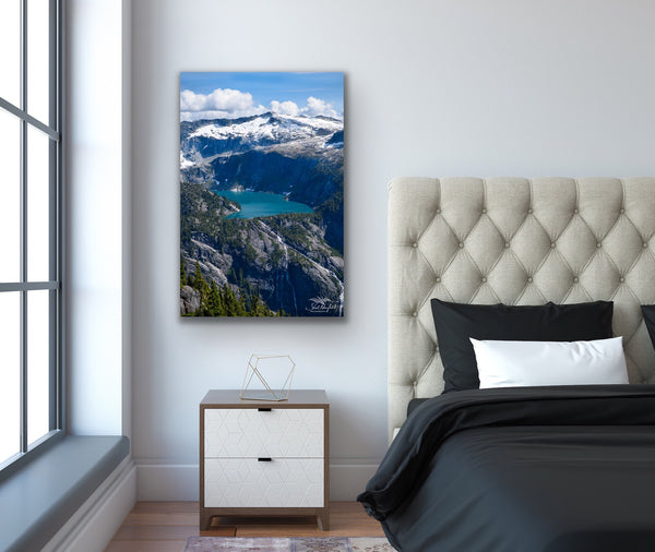 Vertical mountain landscape canvas wall art hangs in a bedroom. Artwork by Shel Neufeld, Canadian landscape and nature photographer. 