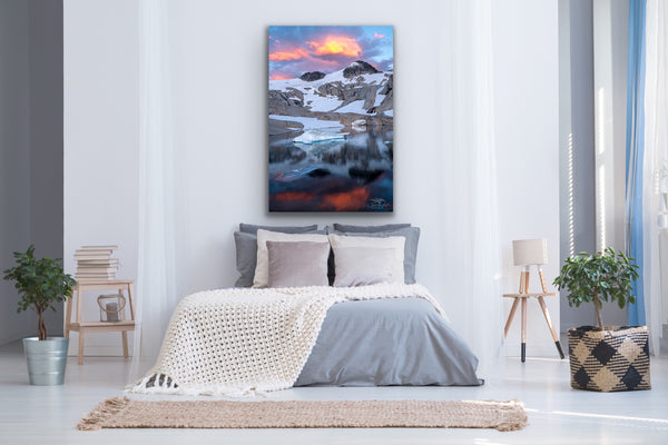 Vertical mountain photography canvas hangs above a bed. Photography by Shel Neufeld. 