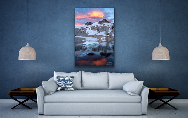 Vertical mountain sunset canvas wall art hangs above a couch in a living room. Artwork by Shel Neufeld from Roberts Creek, BC, Canada. 