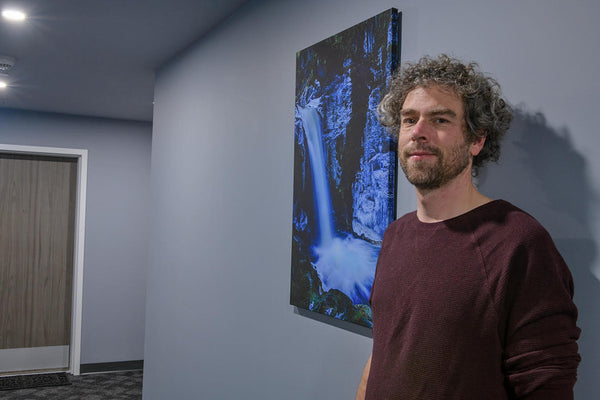 Photographer Shel Neufeld stands in front of one of his photography canvases. This image was commissioned for a housing project on the Sunshine Coast, BC, Canada. 