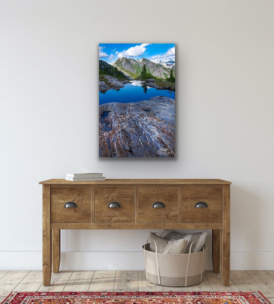 Vertical mountain landscape canvas hangs in a living room. Artwork by Shel Neufeld from Roberts Creek, BC, Canada. 